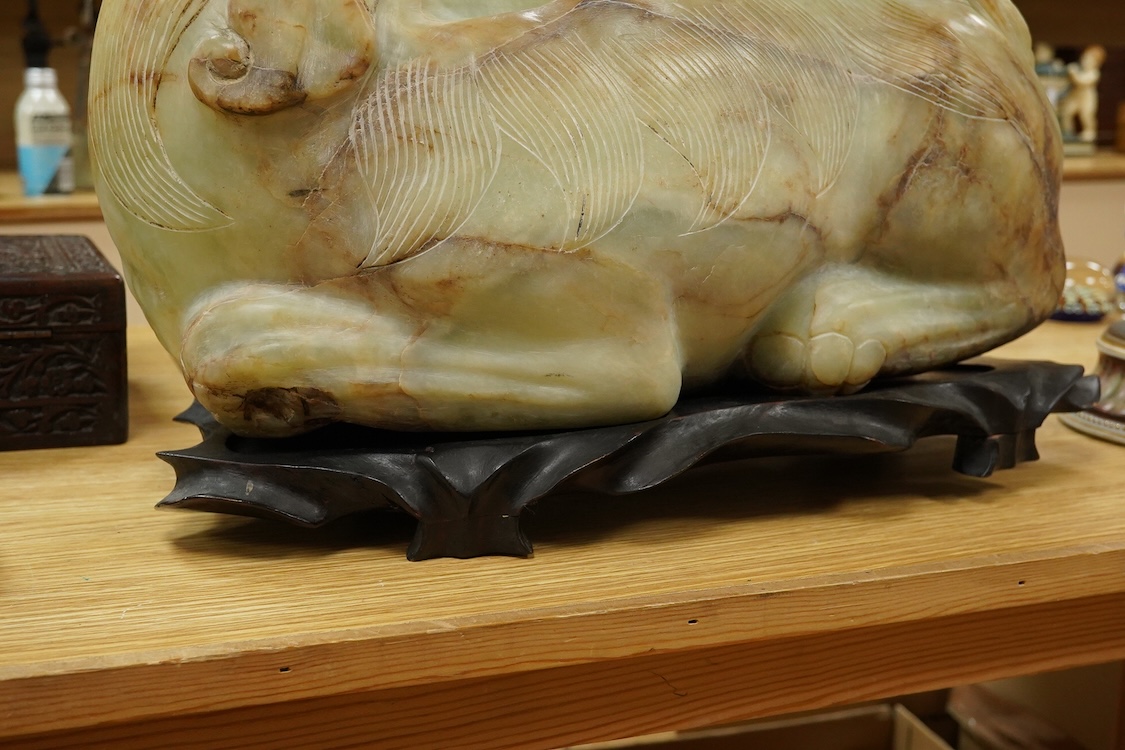 A large Chinese bowenite jade model of a lion dog, wood stand, 44cm